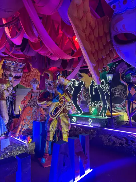 Escenografía de carnaval con máscaras, figuras de músicos y luces de neón