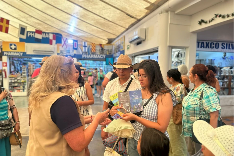 Cruceristas revisan folletos del Gran Acuario Mazatlán